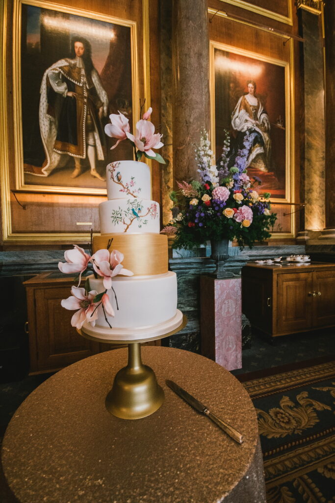 Japanese inspired painted cake with white and gold tiers and magnolia sugar flowers at Drapers Hall