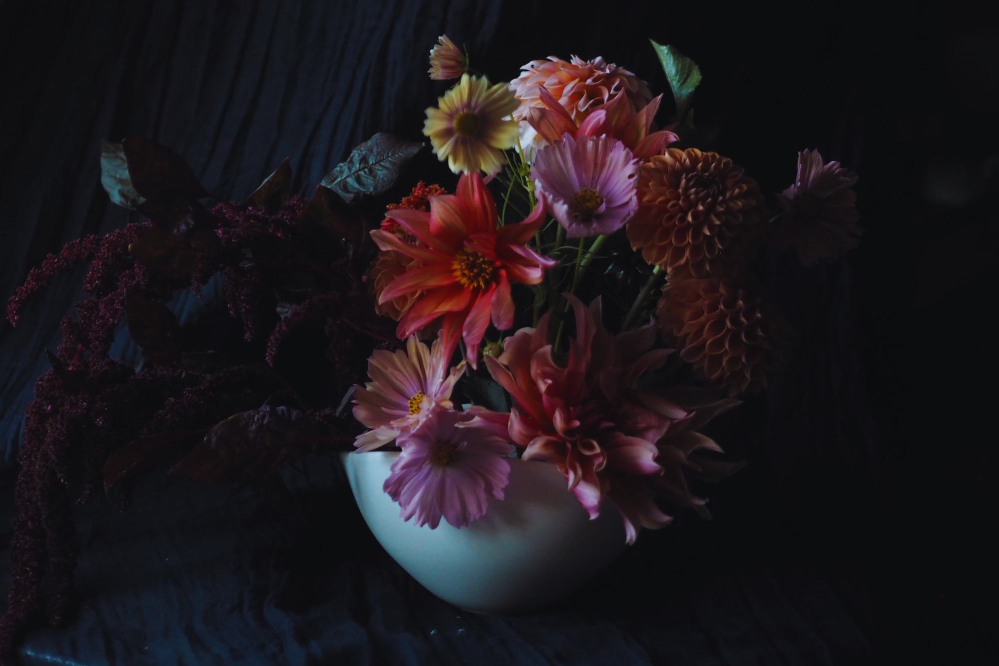 A dark moody Dutch Masters inspired Flower Arrangement with dahlias, amaranthus and cosmos in peach, pink and orange
